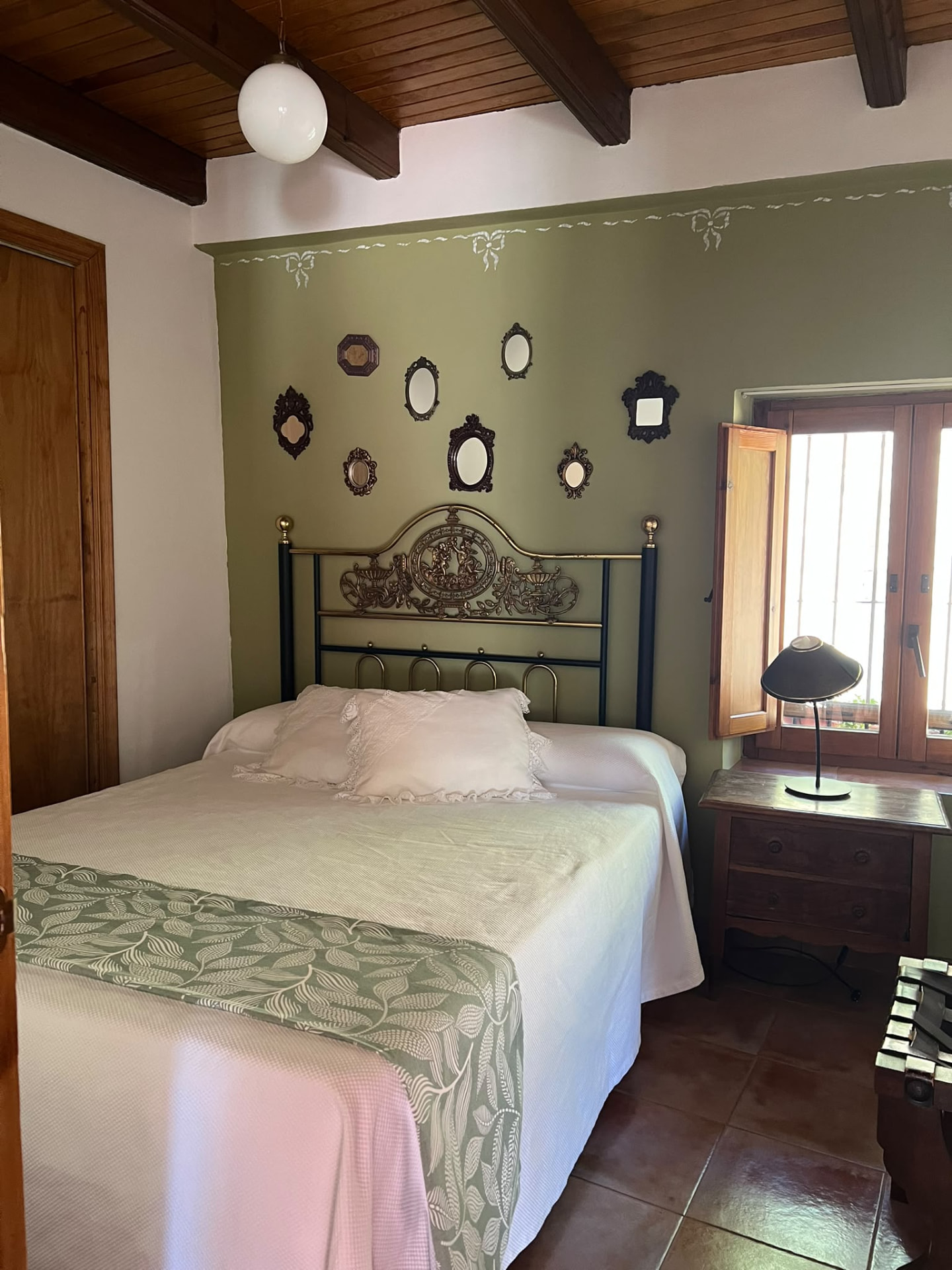 Dormitorio de matrimonio con cabecero de forja del apartamento rural La Quincha en Torrijas
