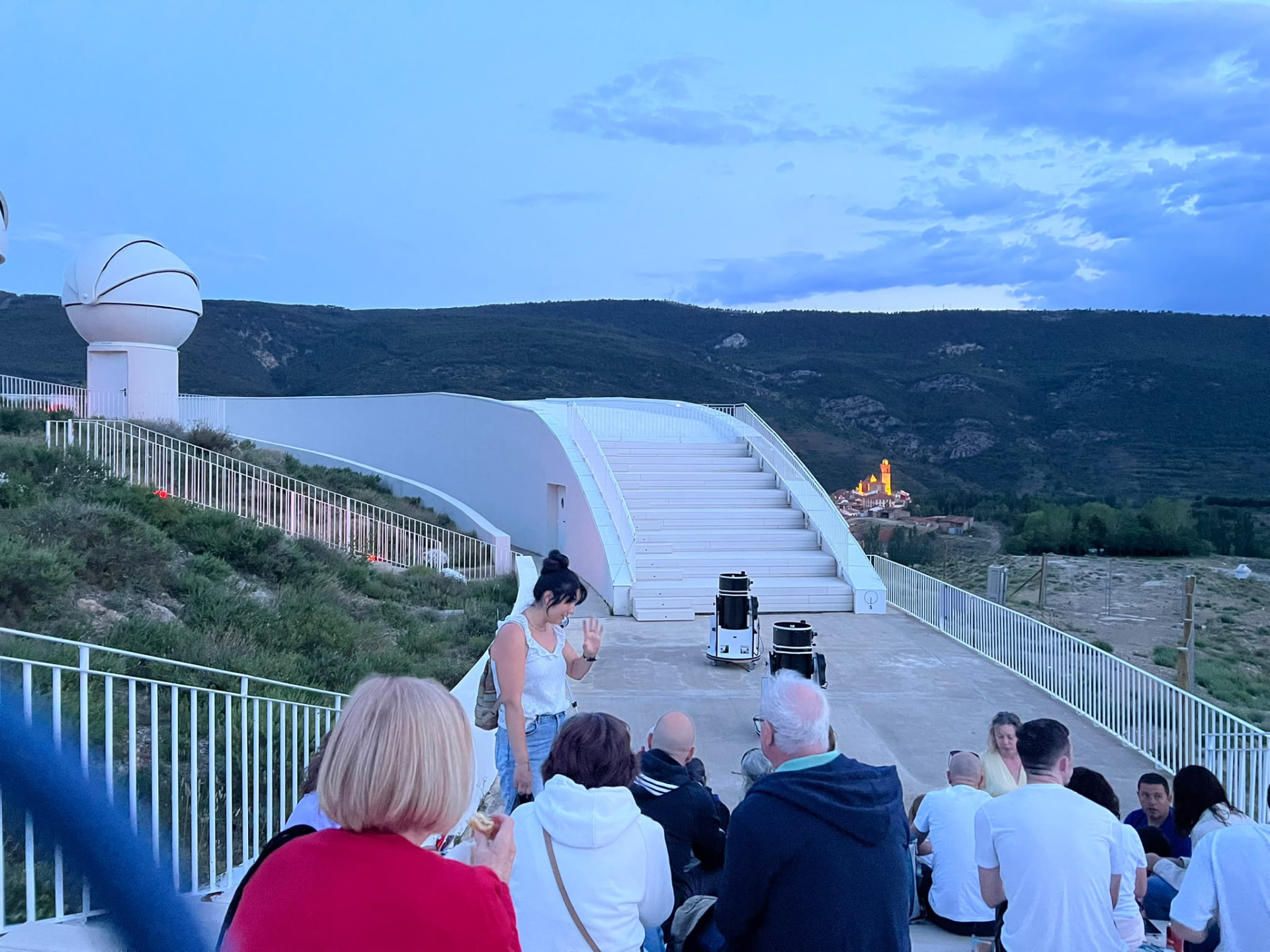 Terraza de observación del centro Galáctica con visitantes y cúpulas al anochecer