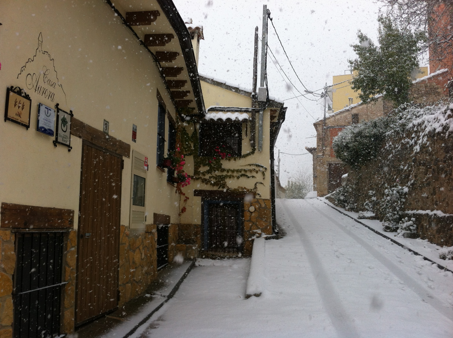 Fachada de Casa Aurora en Torrijas cubierta de nieve durante el invierno